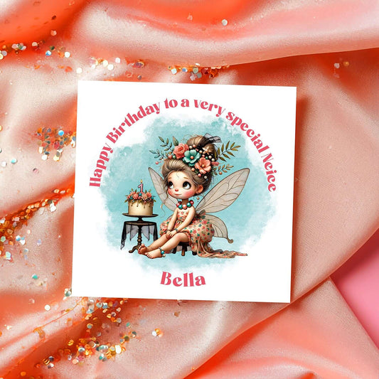Birthday card with a fairy character and cake on a decorative fabric background