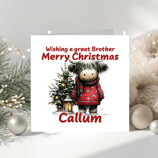 Christmas card with a cow in a red  jumper and  a Christmas tree in the background, surrounded by festive decorations.
