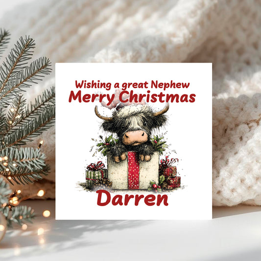 Christmas card with a cartoon cow and a large present and text 'Wishing a great Nephew Merry Christmas Darren, surrounded by a cozy winter background.