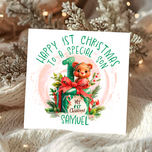 Christmas card with a baby bear and gift, text 'Happy 1st Christmas to a special son', and personalized name 'Samuel' on a decorative background.