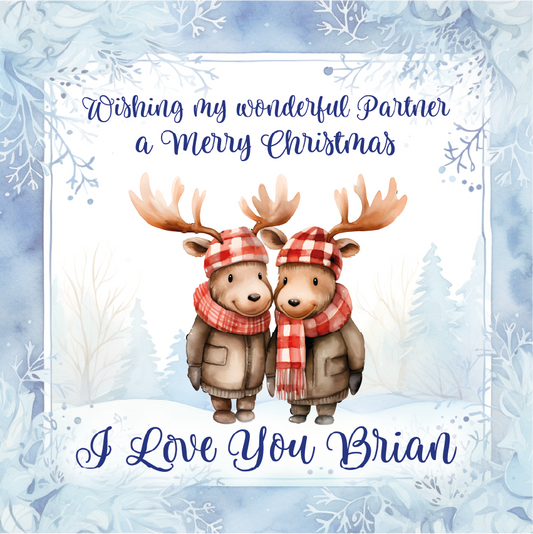  Romantic christmas card with two deer wearing hats and scarves, set against a snowy background.
