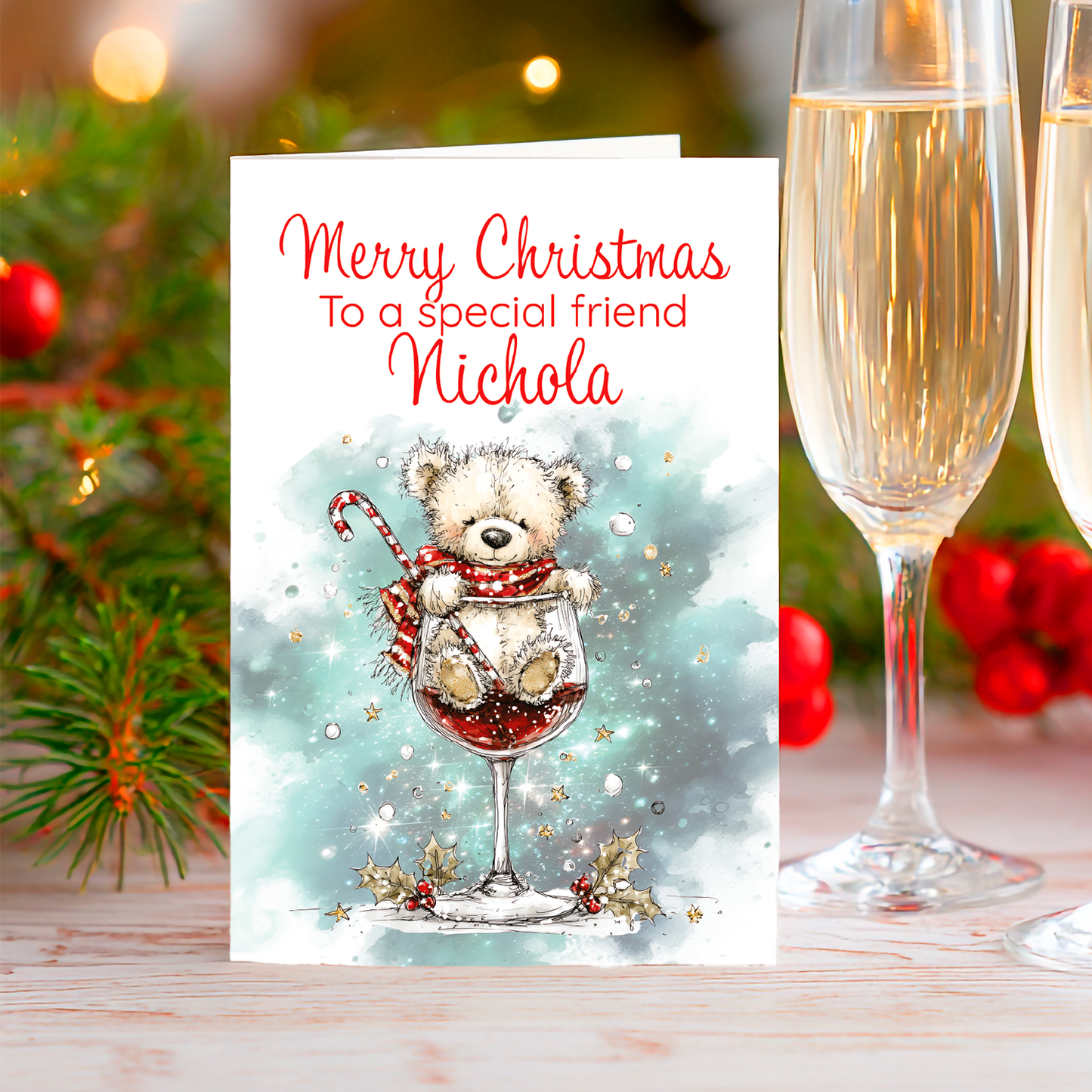 Christmas card with a teddy bear in a wine glass, two champagne glasses, and festive decorations.
