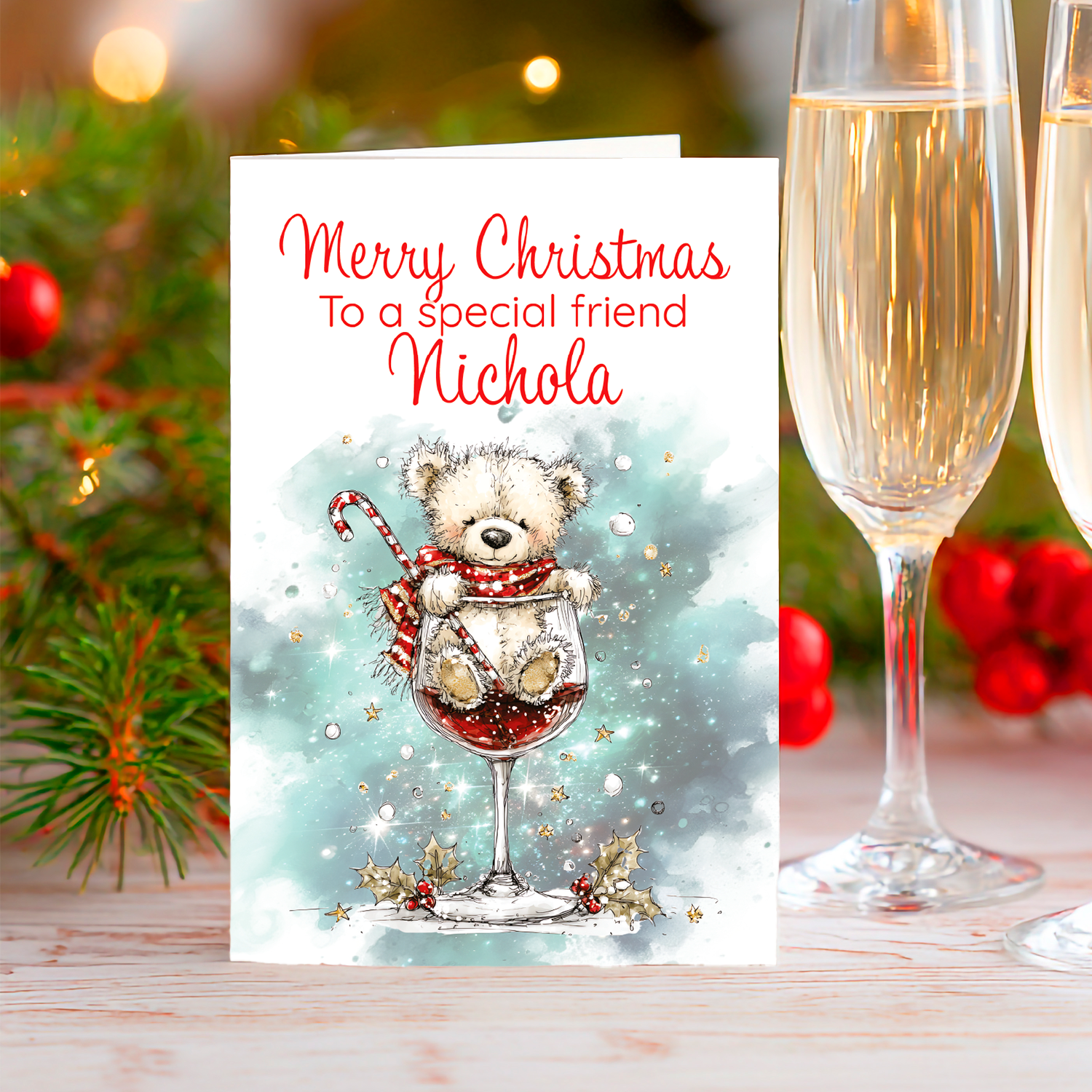 Christmas card with a teddy bear in a wine glass, two champagne glasses, and festive decorations.