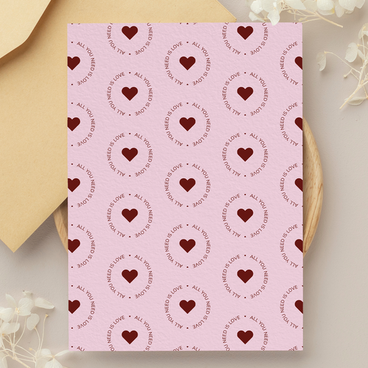 Pink card with heart and text pattern on a beige background