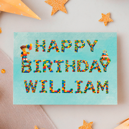 Birthday Card  with Leggo letters that spell out  'Happy Birthday (Name)  with a lego character and birthday cake. Can be personalised for any name 