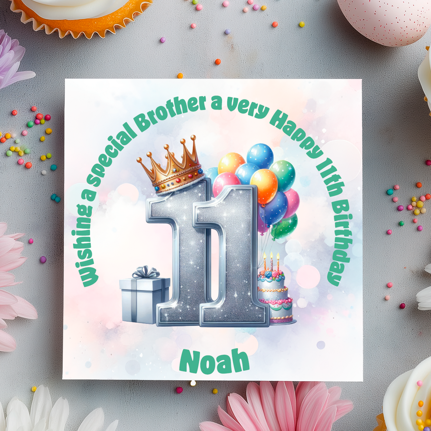 Birthday card with number 11, crown, balloons, and cake on a decorative background with flowers and candies.